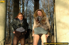 Two girls outdoor pissing on stone columns