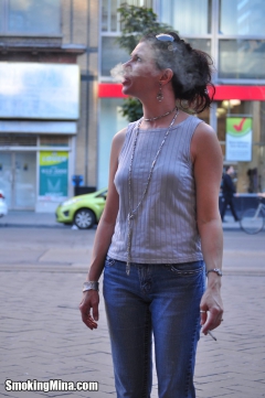 Brunette babe smoking while loitering on the street - N